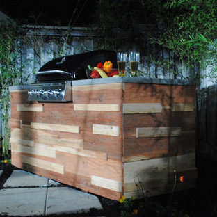 Ispirazione per un patio o portico etnico di medie dimensioni e dietro casa con un focolare, pavimentazioni in cemento e una pergola