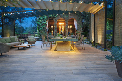Diseño de patio moderno en patio trasero con fuente, adoquines de piedra natural y toldo