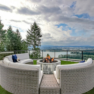 Immagine di un ampio patio o portico country dietro casa con un focolare, cemento stampato e nessuna copertura