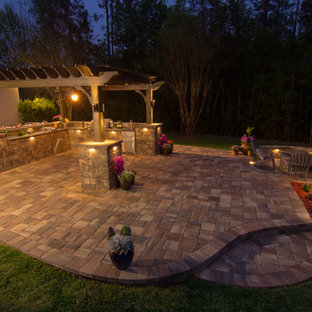 Inspiration for a large timeless backyard stone patio kitchen remodel in Jacksonville with a pergola