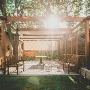 Ispirazione per un grande patio o portico chic dietro casa con pavimentazioni in cemento e una pergola
