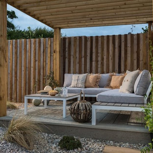 Esempio di un piccolo patio o portico tropicale dietro casa con pedane e una pergola