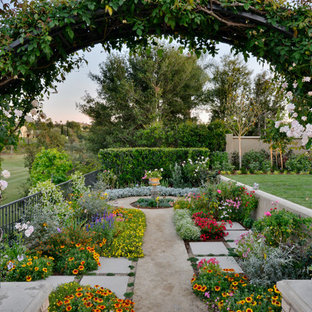 Foto di un ampio patio o portico mediterraneo dietro casa con un giardino in vaso, pavimentazioni in cemento e una pergola