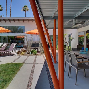 Inspiration for a large 1960s backyard concrete paver patio kitchen remodel in Los Angeles with a pergola