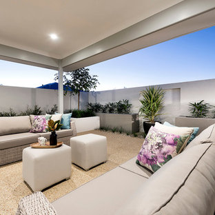 Inspiration pour une terrasse design de taille moyenne avec une cour, une dalle de béton et une extension de toiture.
