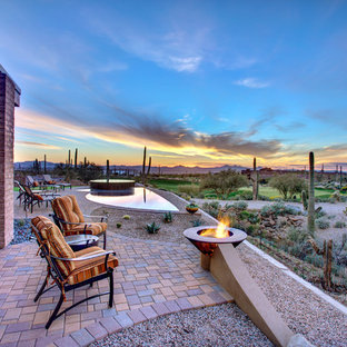 Foto di un patio o portico american style dietro casa con un focolare, pavimentazioni in mattoni e nessuna copertura