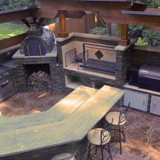 Inspiration for a mid-sized contemporary backyard stamped concrete patio kitchen remodel in Seattle with a roof extension