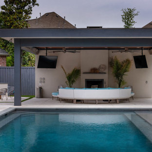 Immagine di un grande patio o portico minimal dietro casa con un caminetto, cemento stampato e una pergola