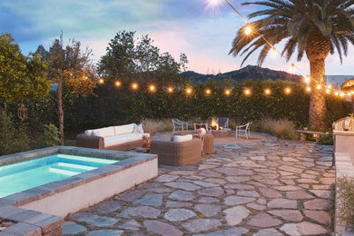 Example of a mountain style backyard stone patio design in Los Angeles with a fire pit
