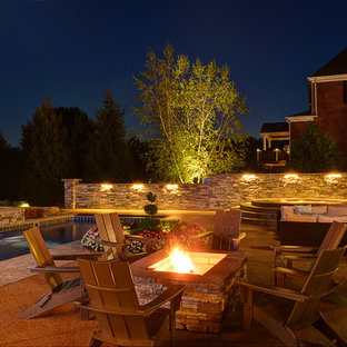 Esempio di un grande patio o portico american style dietro casa con un focolare