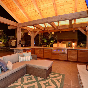 Idee per un grande patio o portico stile americano dietro casa con un gazebo o capanno