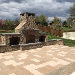 Foto di un grande patio o portico boho chic dietro casa con un focolare e pavimentazioni in cemento