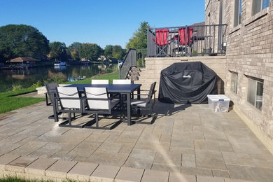 Large minimalist backyard brick patio photo in Detroit with a fire pit and no cover