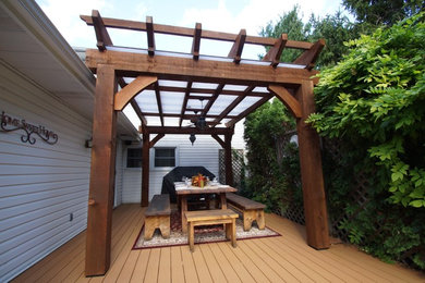 Example of a mid-sized arts and crafts backyard patio design in Toronto with a pergola and decking