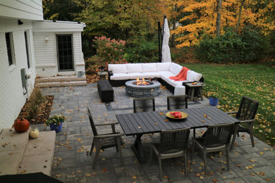 Inspiration for a timeless backyard concrete paver patio remodel in Detroit with a fire pit