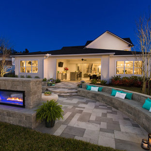 Ispirazione per un ampio patio o portico minimal dietro casa con un focolare, pavimentazioni in pietra naturale e nessuna copertura