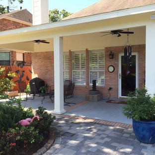 Immagine di un patio o portico classico di medie dimensioni e dietro casa con pavimentazioni in cemento e un tetto a sbalzo