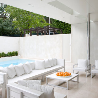 Ispirazione per un patio o portico moderno dietro casa con pavimentazioni in pietra naturale e un tetto a sbalzo