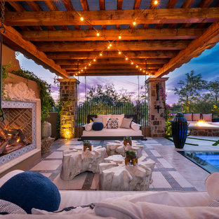 Idee per un ampio patio o portico shabby-chic style dietro casa con un focolare, pavimentazioni in pietra naturale e un gazebo o capanno
