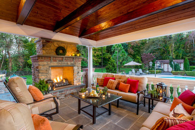 Mid-sized elegant backyard stone patio photo in Philadelphia with a fire pit and a roof extension