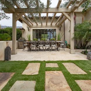 Idee per un patio o portico mediterraneo in cortile con pavimentazioni in pietra naturale e una pergola