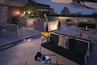 This is an example of a large contemporary back patio in Toronto with an outdoor kitchen, concrete paving and no cover.