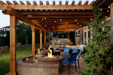 Patio - mid-sized rustic backyard stamped concrete patio idea in Boise with a pergola