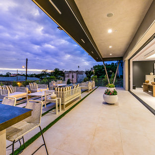 Immagine di un grande patio o portico minimalista dietro casa con un focolare, lastre di cemento e nessuna copertura