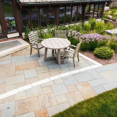 Large elegant backyard stone patio photo in Milwaukee