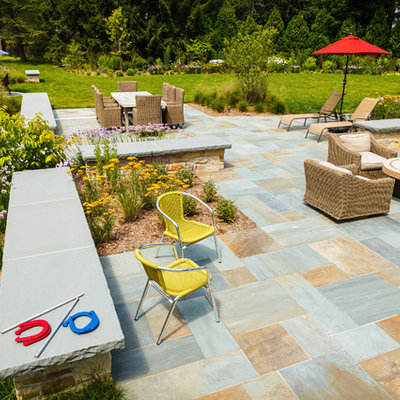 Large elegant backyard stone patio photo in Milwaukee with a fire pit
