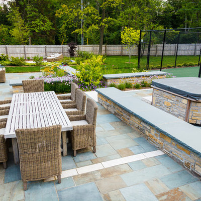 Inspiration for a large timeless backyard stone patio remodel in Milwaukee with a fire pit
