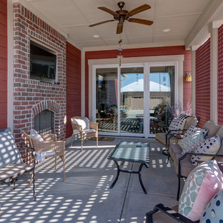 Foto di un piccolo patio o portico stile americano dietro casa con un caminetto, pavimentazioni in cemento e un tetto a sbalzo