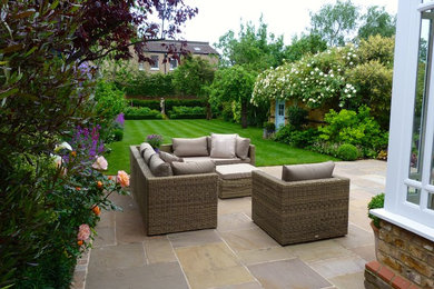 Inspiration for a classic back patio in London with natural stone paving.