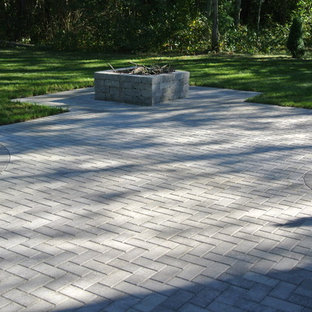 Ispirazione per un patio o portico tradizionale di medie dimensioni e dietro casa con un focolare, pavimentazioni in cemento e nessuna copertura