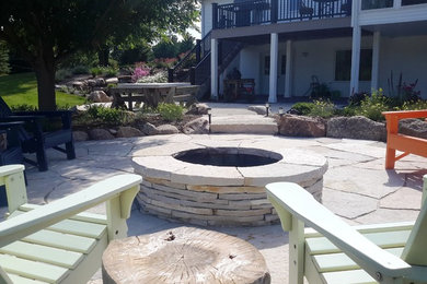 Modelo de patio clásico grande sin cubierta en patio trasero con brasero y adoquines de piedra natural