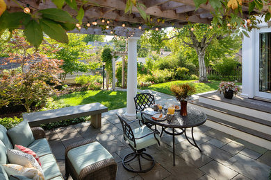 Imagen de patio clásico renovado grande en patio trasero con adoquines de hormigón y pérgola
