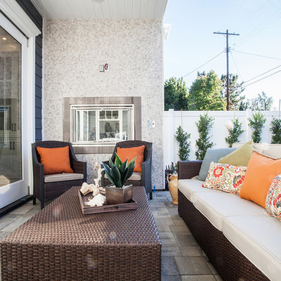 Example of a classic backyard concrete paver patio design in Los Angeles with a roof extension