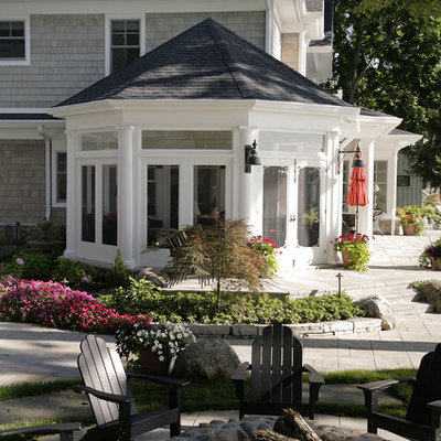 Huge elegant front yard stamped concrete patio photo in Other with a fire pit and a roof extension