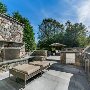 Example of a classic backyard concrete paver patio kitchen design in New York with no cover