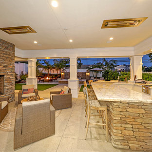 Idee per un ampio patio o portico classico dietro casa con un focolare, graniglia di granito e un tetto a sbalzo