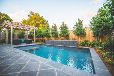 Pool fountain - transitional backyard stone pool fountain idea in New Orleans
