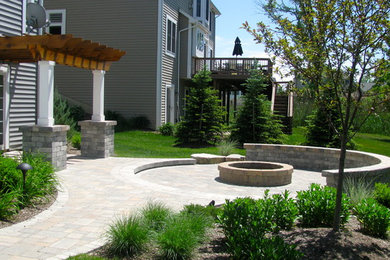 Diseño de patio moderno grande sin cubierta en patio trasero con brasero y adoquines de hormigón