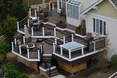 Idée de décoration pour une terrasse en bois arrière tradition de taille moyenne avec un foyer extérieur et une extension de toiture.