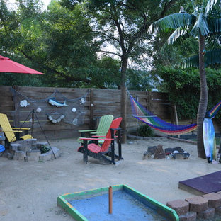 Ispirazione per un patio o portico tropicale di medie dimensioni e dietro casa con un focolare, ghiaia e nessuna copertura