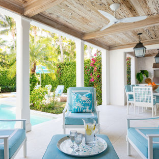 Esempio di un patio o portico tropicale con un tetto a sbalzo
