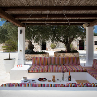 Esempio di un patio o portico mediterraneo con una pergola