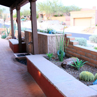 Immagine di un patio o portico american style di medie dimensioni e dietro casa con pavimentazioni in mattoni, fontane e un tetto a sbalzo