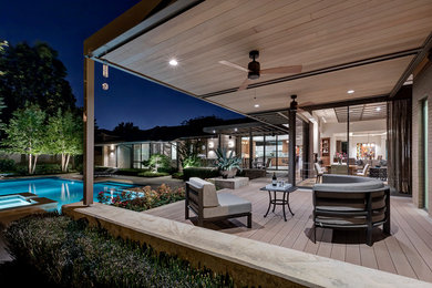 This is an example of a large modern back patio in Dallas with decking and a roof extension.
