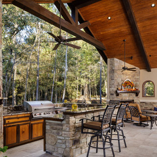 Patio kitchen - large mediterranean backyard tile patio kitchen idea in Houston with a roof extension