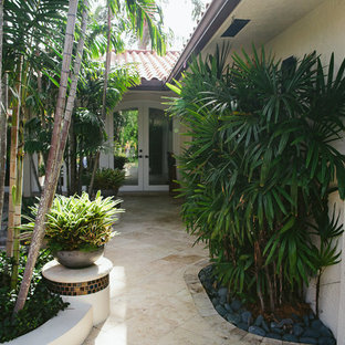 Mid-sized tuscan courtyard stone patio kitchen photo in Miami with a pergola